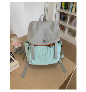 Détail du sac à dos de randonnée tricolore montrant le tissu vert menthe et la boucle métal