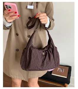 Detail of vintage brown plaid hobo bag with adjustable wide strap and drawstring closure
