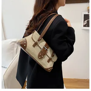 Detailaufnahme der Retro-Schultertasche mit silbernen Nieten und Canvas-Leder-Kontrast