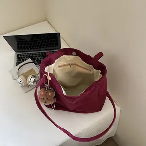 Burgundy corduroy tote bag with plush bear charm and magnetic closure for daily use