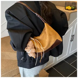 Detail of vintage suede leopard print shoulder bag with cute plush bear pendant accessory