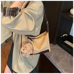 Macro view of vintage leopard suede hobo bag with a cute plush puppy charm detail