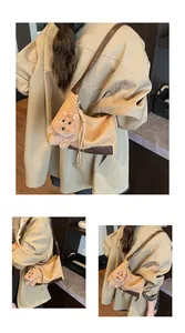 Detail view of khaki corduroy hobo bag with brown leather trim and cute plush puppy charm