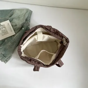 Dunkelbraune gesteppte Tragetasche mit geräumigem Innenraum und Laptopfach in der Draufsicht