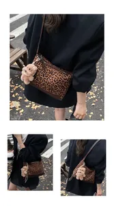 Close-up of leopard print suede shoulder bag with brown leather trim and bear pendant