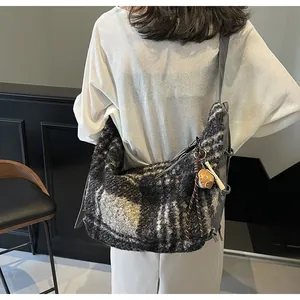 Detailed back view of a large black and white checkered wool tote with a strawberry charm