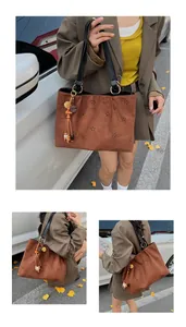 Detail of laser-cut petal pattern and vintage charm on brown suede tote bag