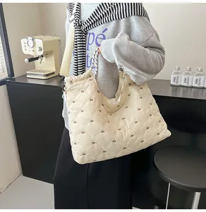 Detail van gewatteerde shopper met strikmotieven en handvat met stippen