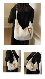 Detail of white wool fleece hobo bag with baseball charm and wide shoulder strap