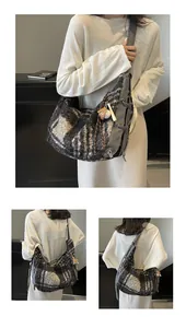 Detail of large wool plaid crossbody bag with wide canvas strap and baseball keychain charm