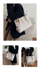 Detail of laser-cut floral pattern on beige suede tote bag with bohemian charm
