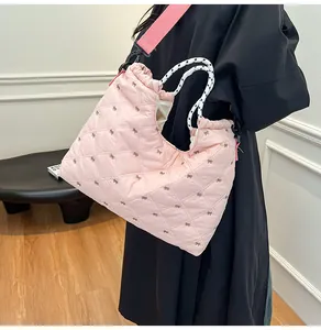 Detail van roze gewatteerde shopper met strikpatronen en geweven touwhandvatten