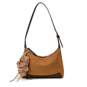 Retro brown suede crescent shoulder bag with dog pendant and dark leather trim