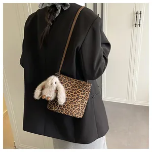 Détail du sac à bandoulière léopard avec un joli pendentif lapin en peluche blanc