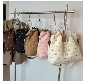 Detail van diverse gewatteerde tote bags met strikjes en gevlochten touwhandvatten