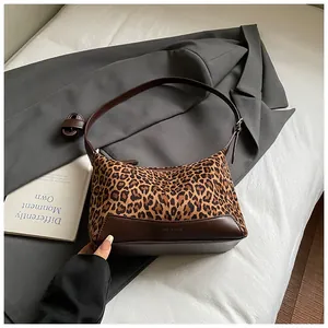 Fashionable leopard print suede underarm bag with dark brown leather straps and accents