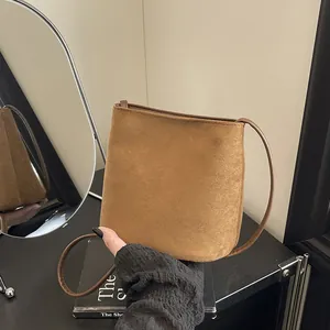 Sac à bandoulière minimaliste en suédine marron avec bandoulière fine et design épuré