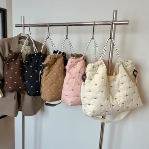 Gewatteerde draagtassen in diverse kleuren met strikmotieven en gestippelde hengsels