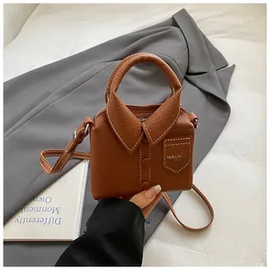 Detail of creative shirt-shaped brown leather handbag with fine stitching and collar