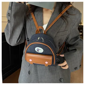 Detail of mini denim and leather patchwork backpack featuring a cute cartoon bear patch