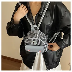 Detail of mini striped backpack featuring a blue leather flap and cute bear patch