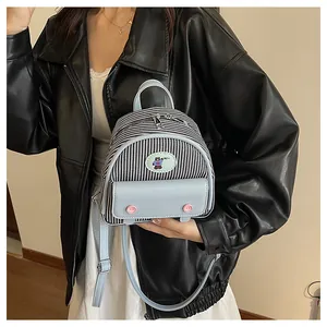 Detailed view of mini striped backpack with blue flap pocket and cute bear patch