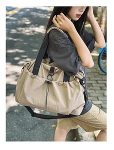 Große khakifarbene Canvas-Reisetasche mit Kordelzugtasche und Gurt in der Straßenansicht