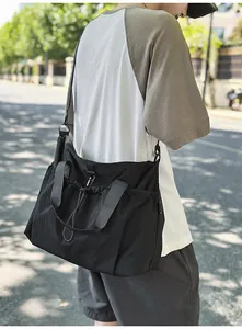Detailansicht der großen schwarzen Nylon-Reisetasche mit Trageriemen und Kordelzug