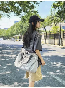 Detailansicht der großen grauen Nylon-Reisetasche mit Kordelzug-Seitentaschen und Gurten