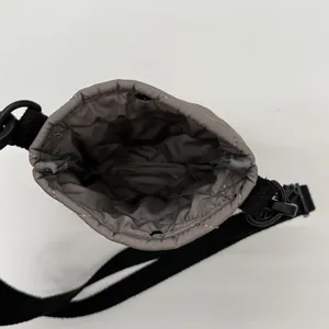 Sac seau matelassé gris avec bandoulière noire et fermeture à cordon réglable