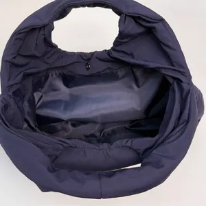 Minimalist navy blue pleated tote bag with spacious interior and magnetic closure