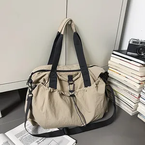 Nahaufnahme der khakifarbenen Reisetasche mit Kordelzug-Seitentaschen und schwarzem Tragegurt