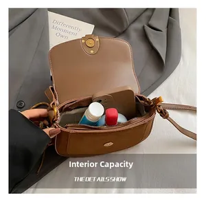 Internal view of brown saddle bag showing capacity for phone and cosmetics