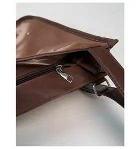 Close-up of silver metal zipper and D-ring on a brown large commuter tote bag