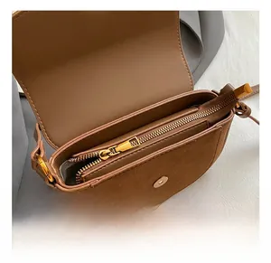 Detail view of the brown leather shoulder bag interior with gold zipper and magnetic closure