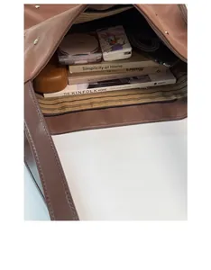 Macro view of spacious brown tote bag interior with striped lining and zipper pocket