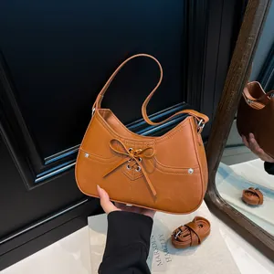 Brown caramel faux leather shoulder bag with decorative bow and top handle