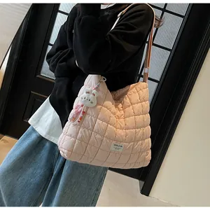Detailed shot of pink quilted cloud bag with plush bunny charm and beaded decor