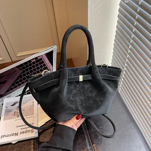 Sac à main noir rétro pour femme avec boucle dorée dans un décor de bureau chic