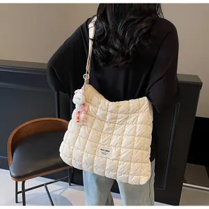 Detail of cream quilted puffer bag with plush bunny charm and beaded accessories