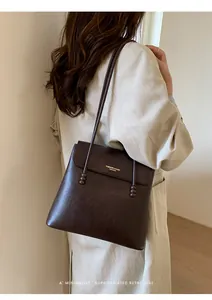 Detailed view of deep brown pebbled leather tote bag with elegant bead strap accents