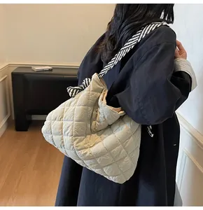 Quilted tote bag with striped straps showing realistic carrying size on a model