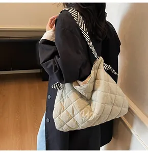 Close-up of quilted tote bag with elegant black and white striped scarf on shoulder strap