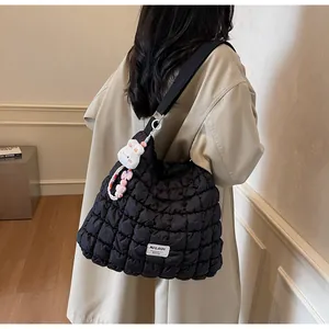 Detail of black quilted cloud bag with white rabbit plush pendant and strap