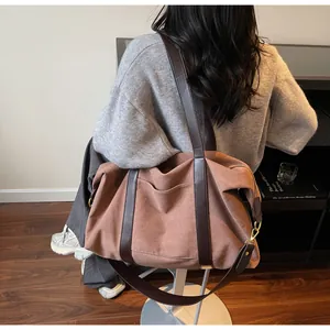 Close-up of a large vintage brown tote bag with leather straps on a model's shoulder