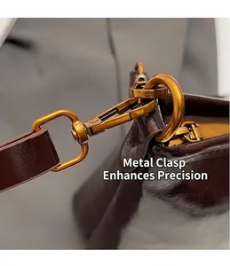 Detail of vintage gold swivel hook and polished brown leather strap on tote bag