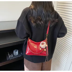 Glossy red faux leather tote bag with a white fluffy sheep charm worn by a model