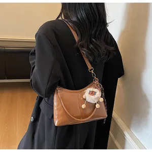 Brown oil-wax leather tote with white plush lamb charm and printed decorative scarf