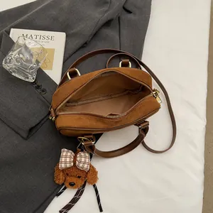 Brown suede bowling bag with teddy bear pendant and adjustable strap for women