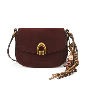 Deep burgundy minimalist saddle bag with gold horseshoe buckle and suede flap